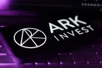 A smartphone displaying the logo for ARK Invest, resting on a keyboard.
