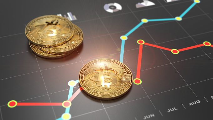 Physical Bitcoin coins rest on top of a financial line chart, symbolizing investment in the asset.