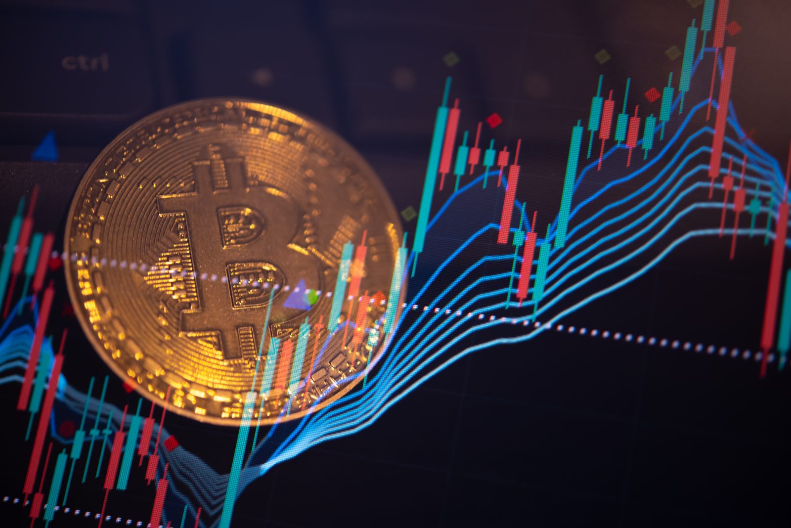 A physical Bitcoin coin overlaid with a volatile digital trading chart featuring red and green candlesticks and trend lines.