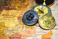 Silver and gold Bitcoin coins resting on a vintage map next to a compass, symbolizing direction and global reach.