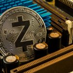 A silver physical Zcash coin resting on internal computer hardware components and heatsinks.